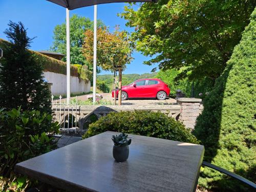 une table avec une voiture rouge garée dans une cour dans l'établissement Appartementen Vouwere, à Malines