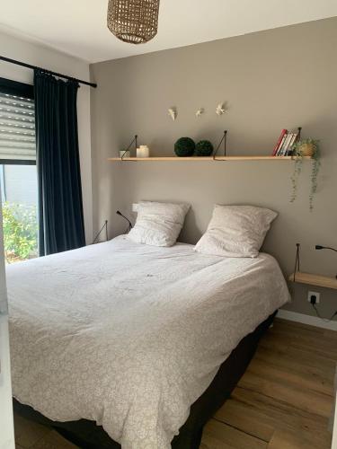 1 dormitorio con 1 cama blanca grande y 2 almohadas en LE REFUGE DE LA BAIE, en Beaussais sur Mer