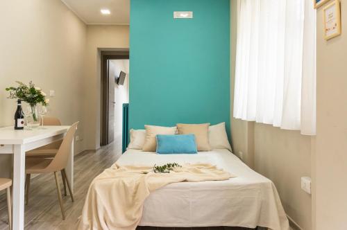 um quarto com uma cama com uma mesa e uma parede azul em Appartamento Al Castello Avezzano em Avezzano