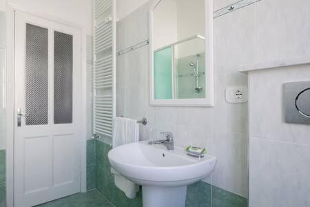 a white bathroom with a sink and a mirror at Casa Orchidea in Sestri Levante