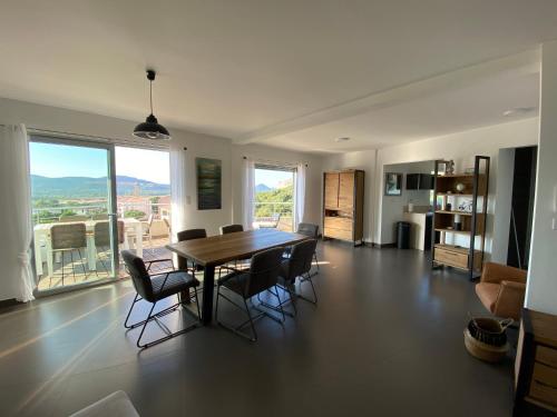 un salon avec une table et des chaises de salle à manger dans l'établissement Le Haut de la Vague, à Porto-Vecchio