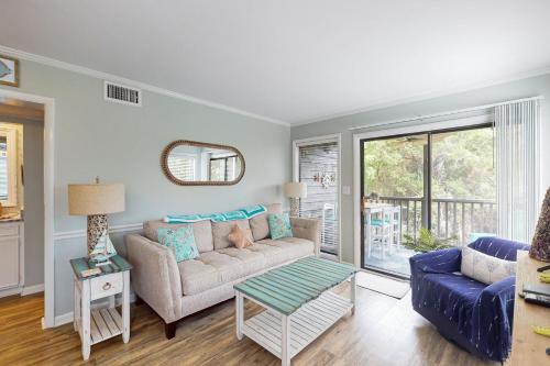 a living room with a couch and a table at Island Beach & Racquet Club H115 in Atlantic Beach