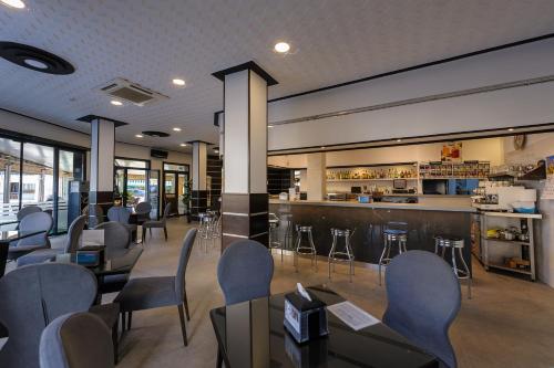 un restaurante con mesas y sillas y un bar en Hotel Costamar, en Morche