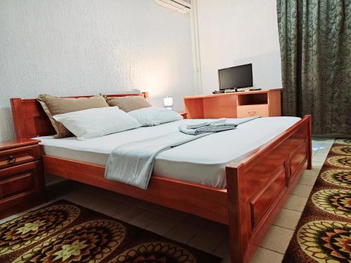 1 dormitorio con 1 cama grande y TV. en Hotel Bravo plus, en Budva