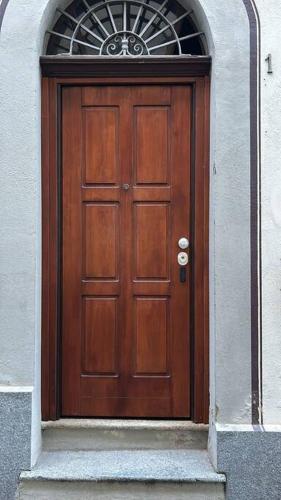 a wooden door in a building with a window at Vicolo Muratori 1 in Moncalieri