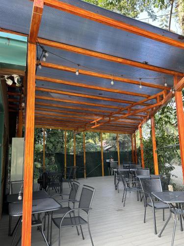 a wooden pergola with tables and chairs on a deck at TortugaBay in Puerto Viejo