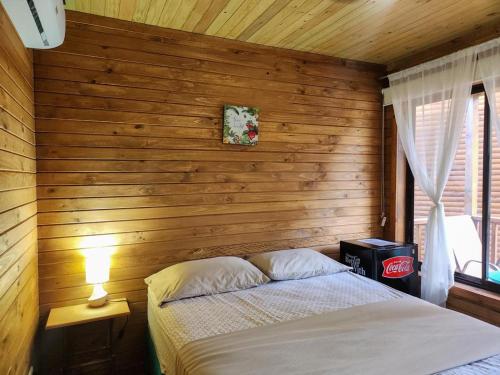 um quarto com uma cama e uma parede de madeira em TortugaBay em Puerto Viejo