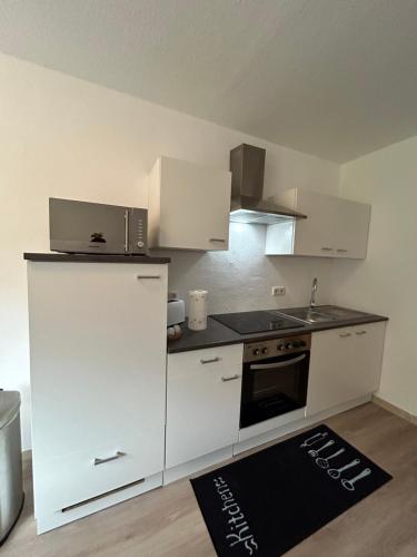 a kitchen with a white refrigerator and a sink at Ferienwohnung Mittenaar in Mittenaar