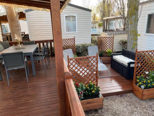 una terraza de madera con mesa y sillas en una casa en Mobil-Home Clos 14 à VIAS, en Vias