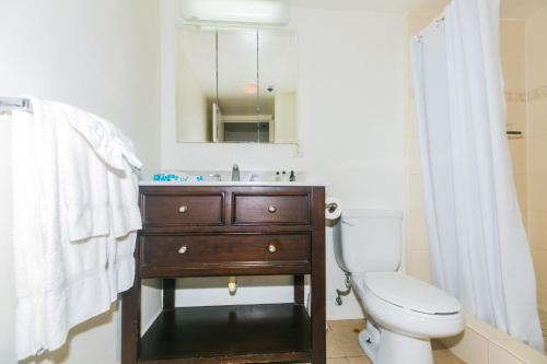 a bathroom with a sink and a toilet and a mirror at Ilikai Tower 1127 Yacht Harbor View 1BR in Honolulu