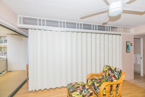 a living room with a chair and a white curtain at Ilikai Tower 1314 Lagoon View 1BR in Honolulu