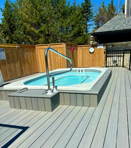 a pool with a hot tub on a wooden deck at Mountain Side Condo Loft at The Blue Mountains in Blue Mountains