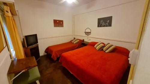 una camera d'albergo con due letti e una televisione di Hotel del Paseo a Mar del Plata