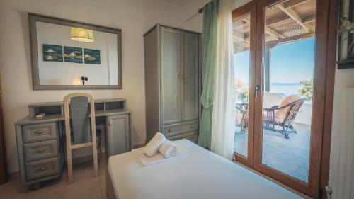 a bedroom with a bed and a view of a balcony at Zeus Sea View Villa with Private Pool, Afytos in Afitos