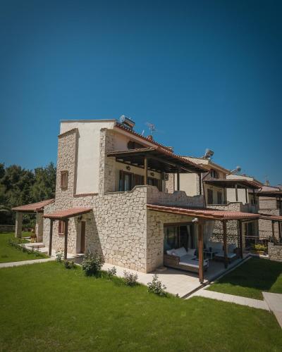an external view of a house with a green lawn at Zeus Sea View Villa with Private Pool, Afytos in Afitos