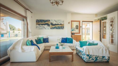 a living room with two white couches and a table at Zeus Sea View Villa with Private Pool, Afytos in Afitos