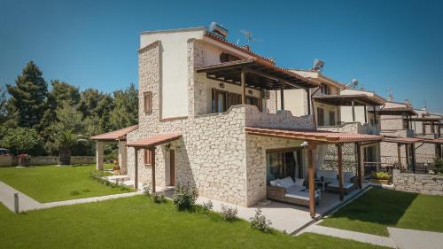 an external view of a house with a lawn at Zeus Sea View Villa with Private Pool, Afytos in Afitos