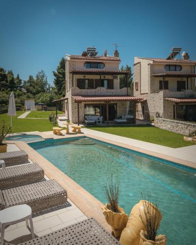 a house with a swimming pool in front of a house at Zeus Sea View Villa with Private Pool, Afytos in Afitos