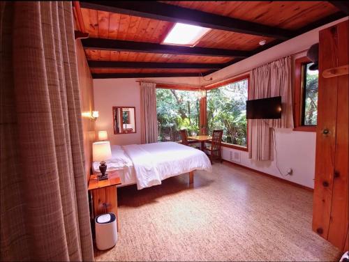 a bedroom with a bed and a large window at The Pacifica Inn in Volcano