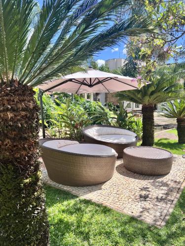 a patio with two benches and an umbrella at View467LifeResortBR in Brasilia
