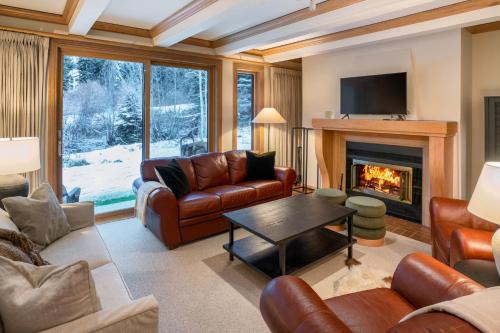 a living room with leather furniture and a fireplace at Creekside at Beaver Creek in Beaver Creek