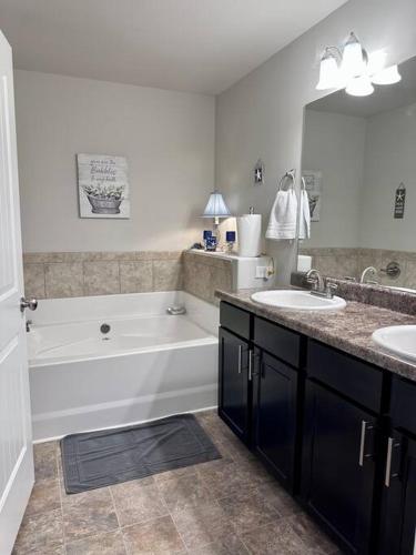 uma casa de banho com uma banheira e 2 lavatórios e uma banheira em Spacious 4 BR in Suburban Metro Atlanta em McDonough