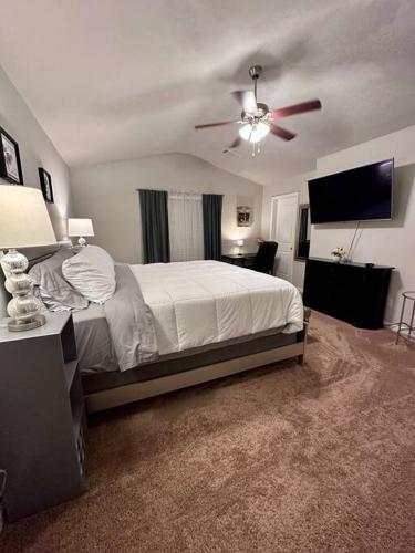 um quarto com uma cama e uma ventoinha de tecto em Spacious 4 BR in Suburban Metro Atlanta em McDonough