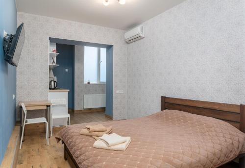 a bedroom with a bed and a table and a chair at Блакитна студия, Південний вокзал 5 хвилин in Kharkiv