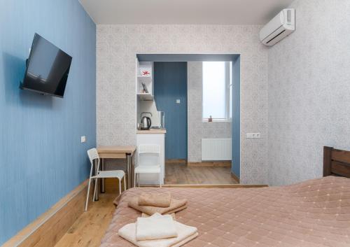 een slaapkamer met een bed en een tv aan de muur bij Блакитна студия, Південний вокзал 5 хвилин in Charkov