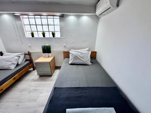 a small room with two beds and a window at Four Seasons - The White Queen House in Kriopigi