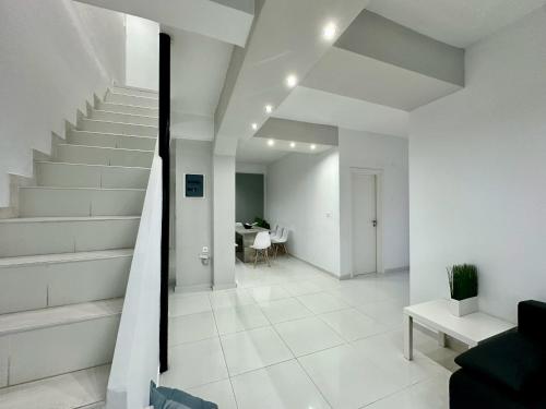 a white hallway with stairs and a dining room at Four Seasons - The White Queen House in Kriopigi