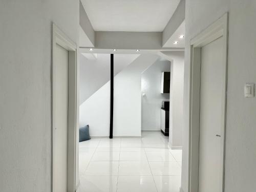 an open hallway with white walls and white tile floors at Four Seasons - The White Queen House in Kriopigi