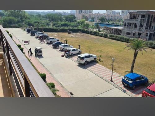 una fila di auto parcheggiate in un parcheggio di Vrindavan serenity hotel & suites a Vrindāvan