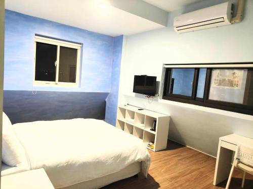 a bedroom with a white bed and a window at Xinyuanbao Shangshi Homestay in Donggang