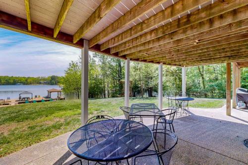 a patio with tables and chairs and a view of a lake at Plum Paradise in Glenora