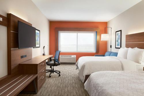 a hotel room with two beds and a flat screen tv at Holiday Inn Express & Suites - Beaver Dam by IHG in Beaver Dam