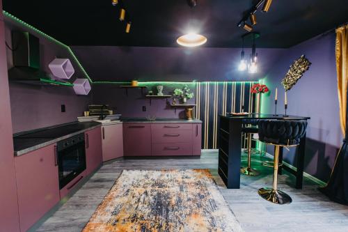 a kitchen with purple and green walls and a table at NL Studio Apartments in Nevesinje