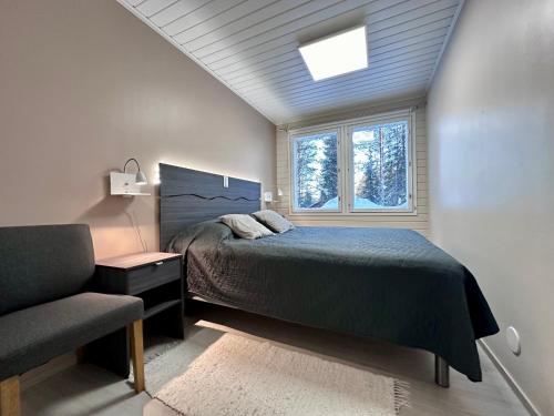 1 dormitorio con cama, ventana y silla en Villa Kiviaapa in Ruka Kuusamo, en Ruka