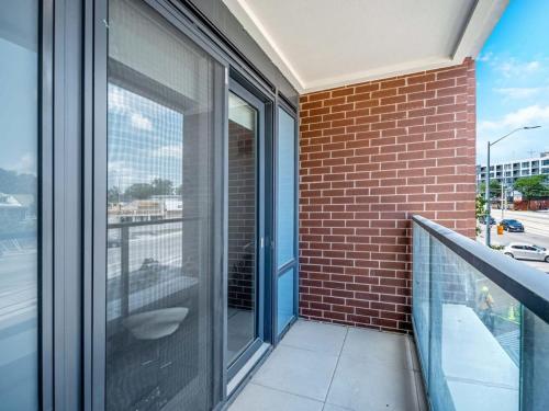 キッチナーにあるCity View - 1BR Condo - Private Balcony Queen Bedのガラスドアとレンガの壁が特徴のバルコニー