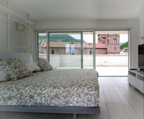 a bedroom with a bed and a large window at SWEETHOME MUSEO - con Garage in Bolzano