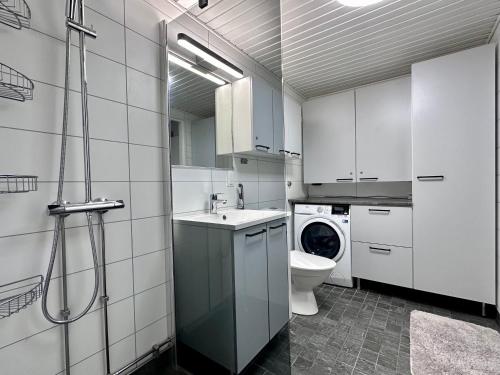 La salle de bains est pourvue de toilettes, d'un lavabo et d'un lave-linge. dans l'établissement Villa Kiviaapa in Ruka Kuusamo, à Ruka