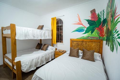 Casa Águila y Cóndor في ليما: غرفة نوم بسريرين بطابقين ولوحة على الحائط