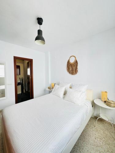 1 dormitorio blanco con 1 cama grande con sábanas blancas en Ático en Sanlúcar de Barrameda, en Sanlúcar de Barrameda