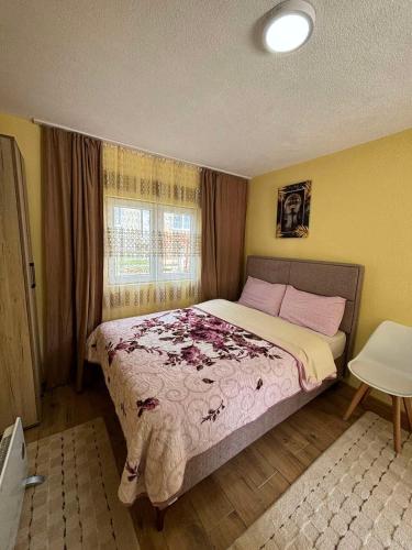 1 dormitorio con 1 cama grande con sábanas rosas y ventana en Studio apartmani Anastasija, en Žabljak