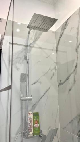 uma casa de banho com chuveiro e mármore branco em Appartamento moderno Freidour, metro Rivoli em Turim