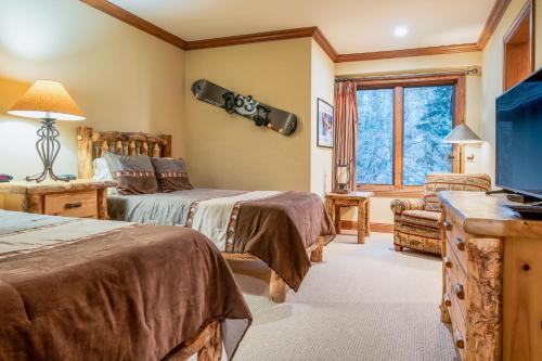 a bedroom with two beds and a snowboard on the wall at Creekside at Beaver Creek in Beaver Creek