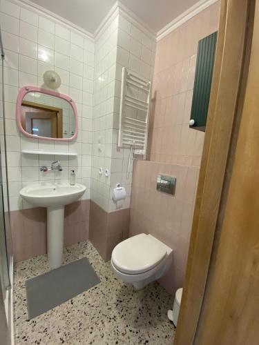 różowa łazienka z toaletą i umywalką w obiekcie Lux Lotnisko we Wrocławiu