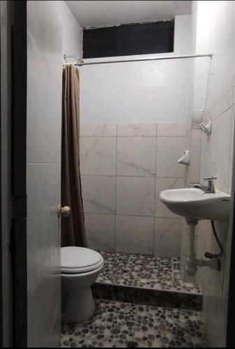 y baño con aseo y lavamanos. en Condominio Confortable, en Talara