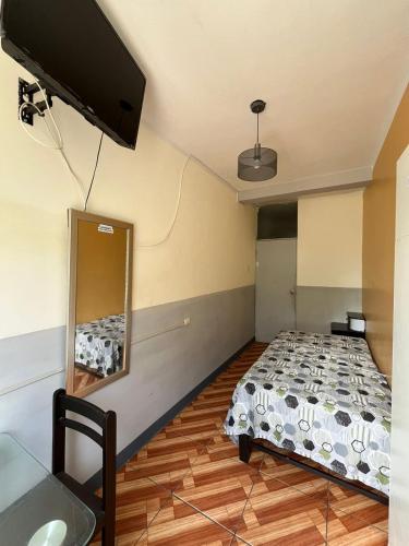 1 dormitorio con 1 cama y TV en la pared en Condominio Confortable, en Talara