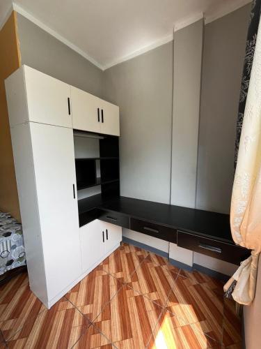 Habitación con armarios blancos y suelo de madera. en Condominio Confortable, en Talara
